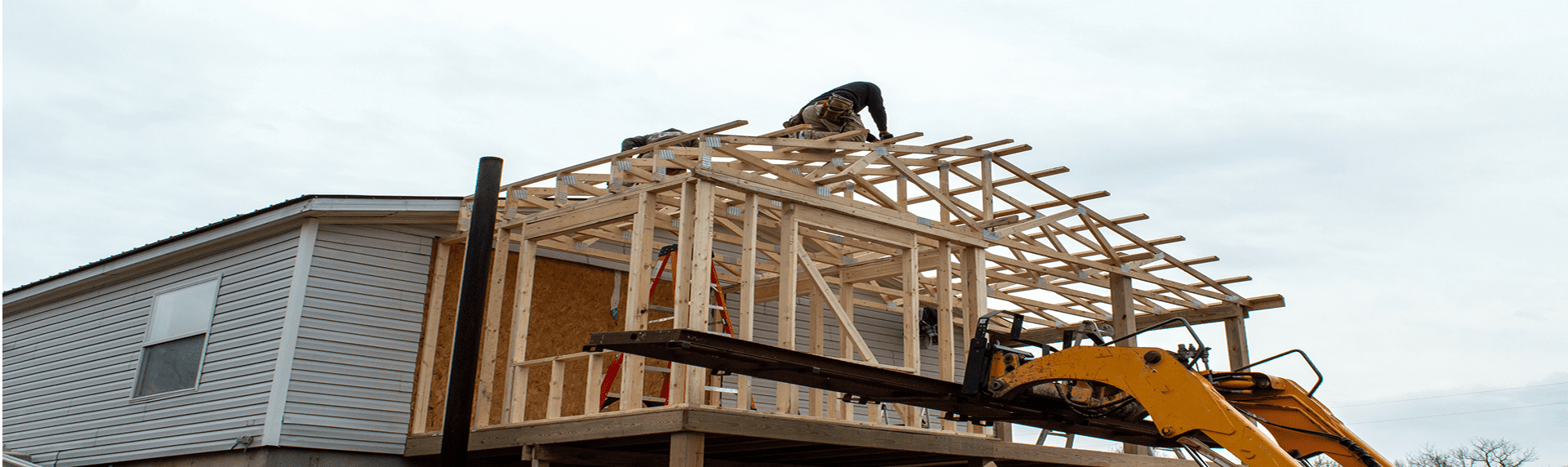 Construction worker framing roof on house